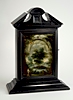 An antique Italian night clock in an ebonised fruitwood case.